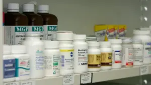Ein mit verschiedenen Medikamenten gefülltes Regal in einer Apotheke oder Praxis.