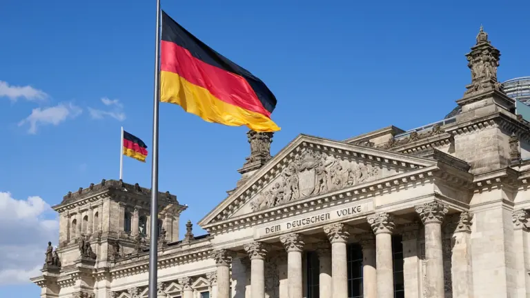 Die deutsche Flagge weht stolz vor dem historischen Reichstagsgebäude in Berlin.