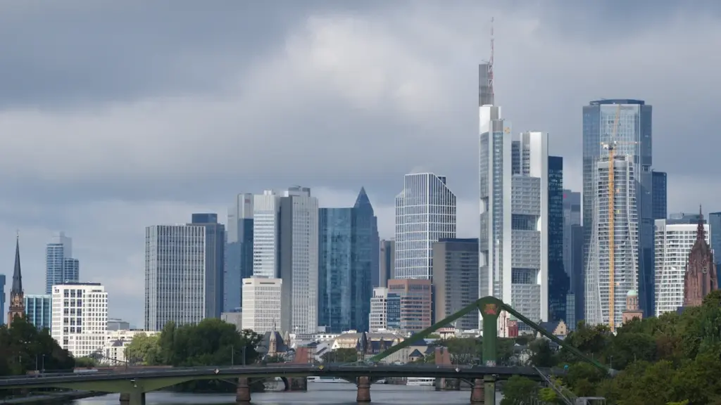Die Frankfurter Skyline mit modernen Hochhäusern und dem Mainfluss an einem bewölkten Tag.