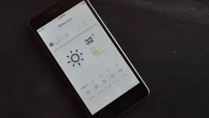 Ein Smartphone zeigt eine Wetter-App mit aktuellen Temperaturdaten und Vorhersagen.
