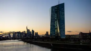 Die Europäische Zentralbank und die Frankfurter Skyline bei Sonnenuntergang über dem Main.