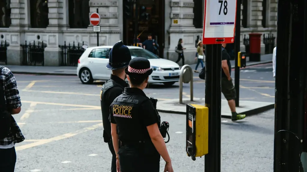 Polizeikräfte der City of London Police stehen an einer belebten Londoner Straßenkreuzung.