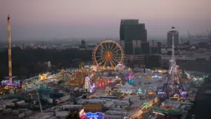 Weitläufige nächtliche Ansicht des Hamburger Doms mit beleuchtetem Riesenrad und Stadtpanorama.