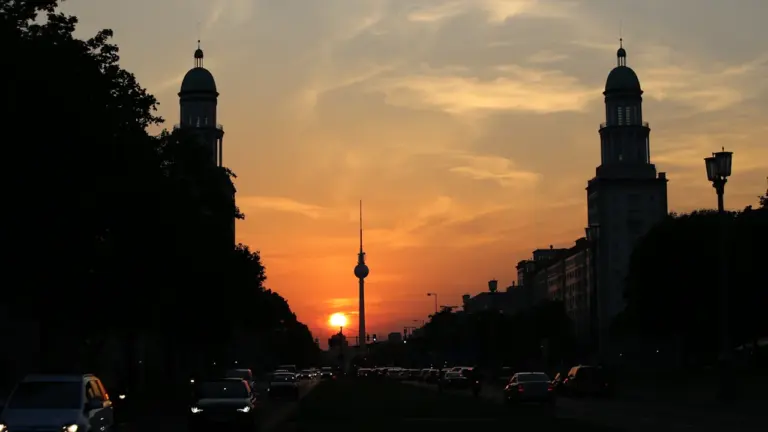Der Berliner Fernsehturm bei einem atmosphärischen und warmen Sonnenuntergang in der Stadt.