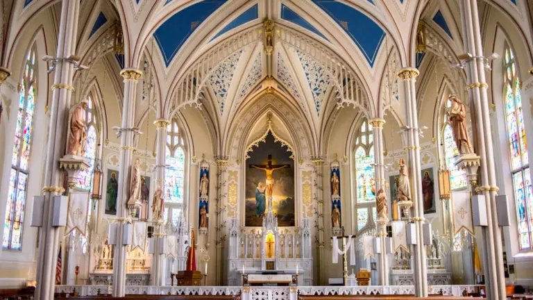 Prunkvoller Innenraum einer katholischen Kirche mit goldenen Verzierungen und religiösen Statuen.