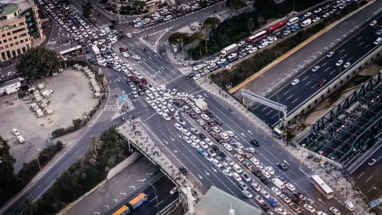 Luftaufnahme eines dichten Staus auf einer großen Autobahnkreuzung bei Tageslicht.