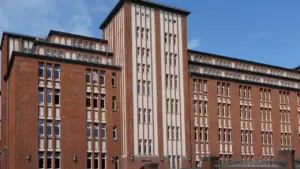 Ein großes, historisches Backsteingebäude mit vielen Fenstern in Hamburg an einem sonnigen Tag.