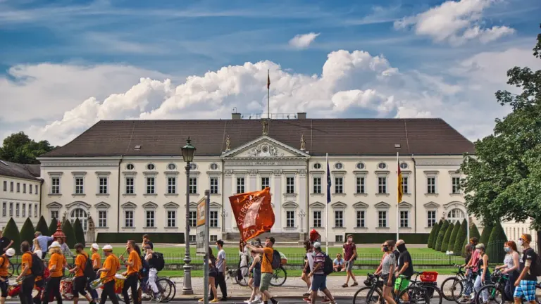 Menschen beim Spaziergang in einer deutschen Stadt im Tageslicht, belebte städtische Umgebung.