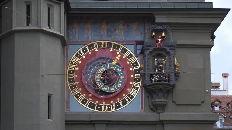 Detailaufnahme einer historischen astronomischen Uhr mit Zodiak-Symbolen an einer Gebäudefassade.