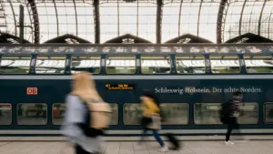 Menschen am Hamburger Hauptbahnhof vor einem einfahrenden Zug der Deutschen Bahn