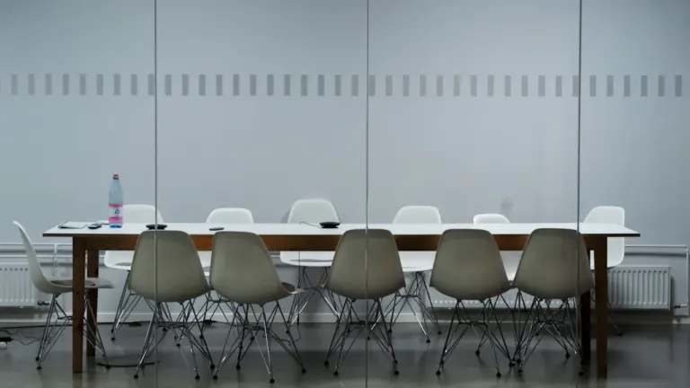 Moderner, leerer Konferenzraum mit langem Tisch für fokussiertes Arbeiten im Büro.