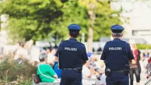 Polizeibeamte in Uniform beobachten eine öffentliche Fläche in Deutschland bei Tageslicht.