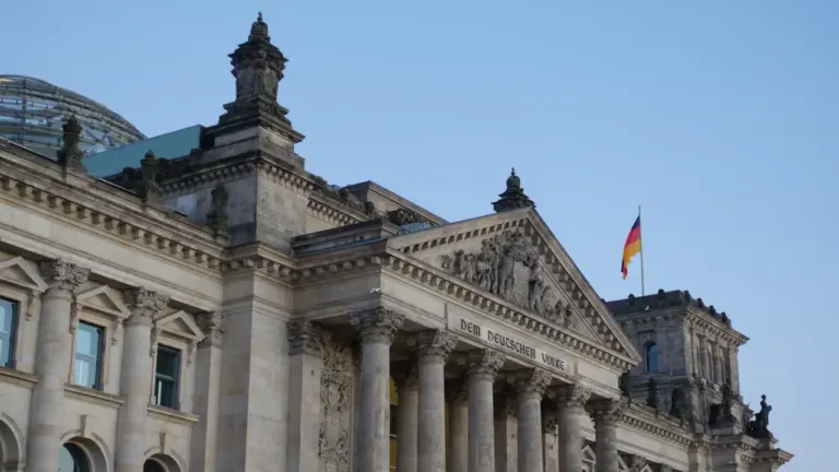 Das Reichstagsgebäude in Berlin unter einem klaren blauen Himmel bei Tageslicht.