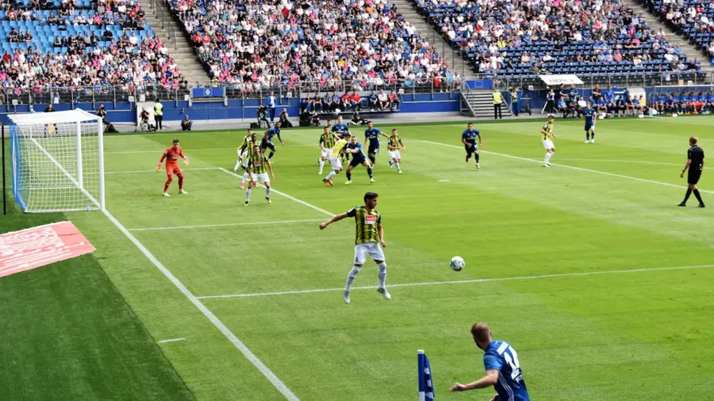 Ein Fußballspiel im Hamburger Volksparkstadion mit Spielern auf dem grünen Rasen.